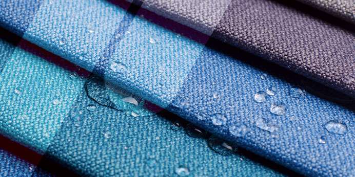 Various colored fabrics overlapping with drops of water sitting on top