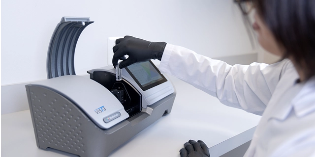 Scientist loading a clear soap sample into the HunterLab Vista Spectrophotometer