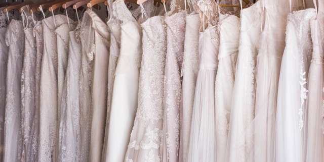 A variety of white wedding dresses hanging next to each other